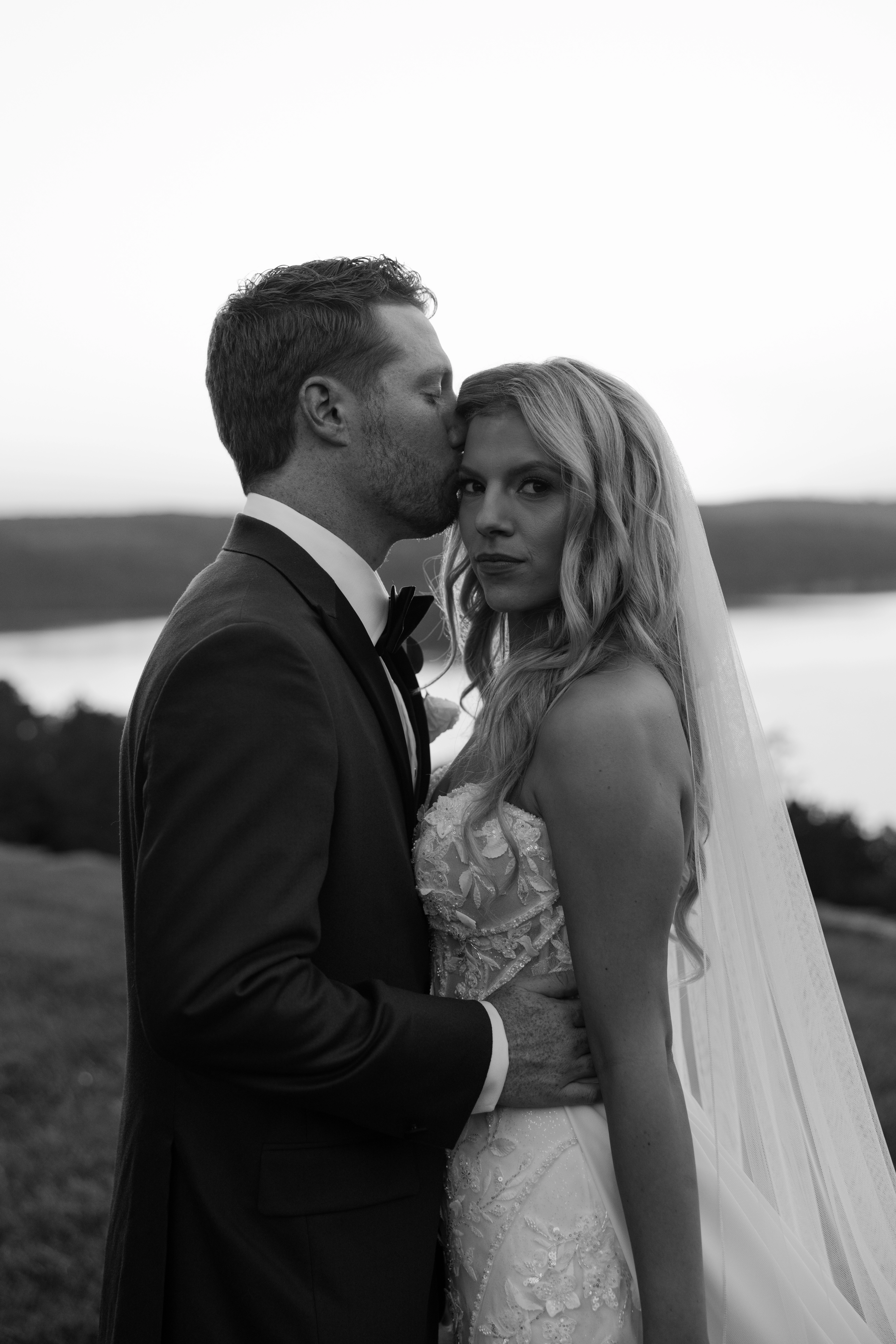 Groom kissing bride during wedding portrait session